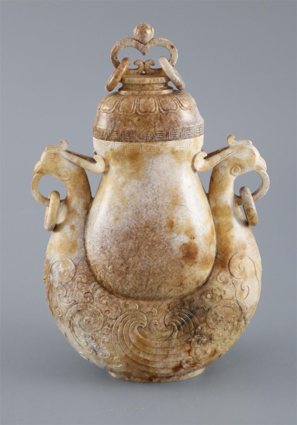 A Chinese archaistic burnt jade phoenix vase and cover, 20cm high